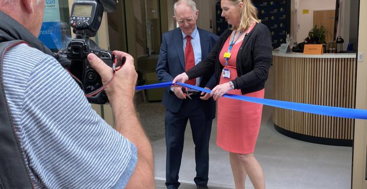 Two people cutting a ribbon at an opening ceremony