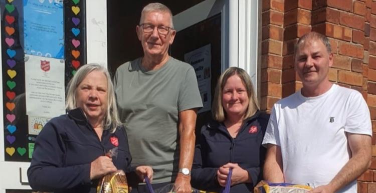 Two female members of Salvation Army and two male volunteers accepting food donations