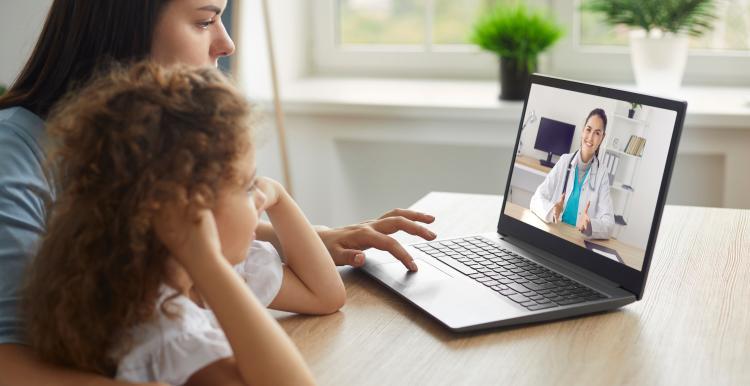 woman_and_young_girl_sitting_down_talking_to_a_doctor_on_the_laptop