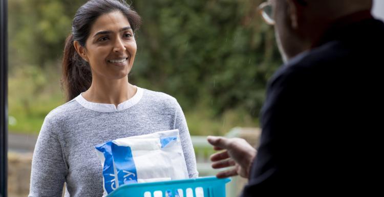 a_smiling_woman_delivering_medication_to_a_man