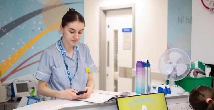 young_woman_nurse_looking_at_an_electronic_device_in_a_hospital