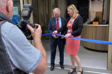 Two people cutting a ribbon at an opening ceremony