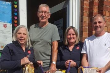 Two female members of Salvation Army and two male volunteers accepting food donations