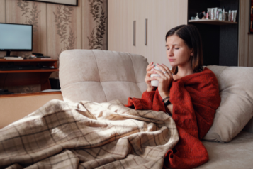 woman_wrapped_in_blankets_drinking_a_hot_drink