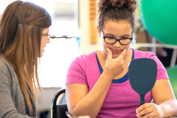 female_speech_therapist_helping_young_female