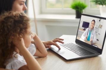 woman_and_young_girl_sitting_down_talking_to_a_doctor_on_the_laptop