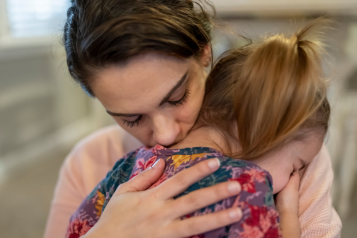 dark_haired_woman_hugging_a_small_child