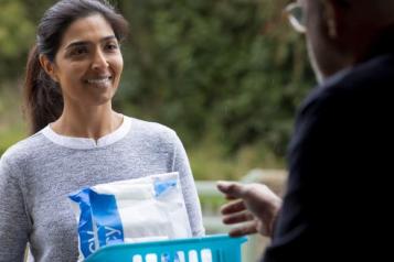 a_smiling_woman_delivering_medication_to_a_man