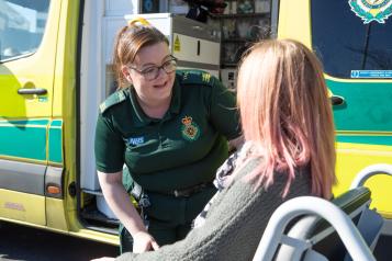 woman_in_a_wheel_chair_outside_an_ambulance_talking_to_paramedic