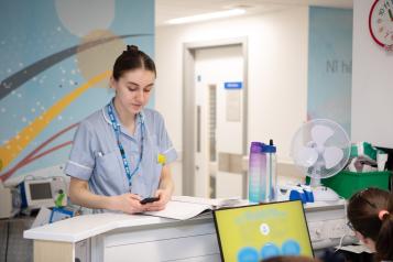 young_woman_nurse_looking_at_an_electronic_device_in_a_hospital