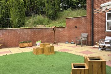 photograph showing outside space with artificial grass and home made wooden planters