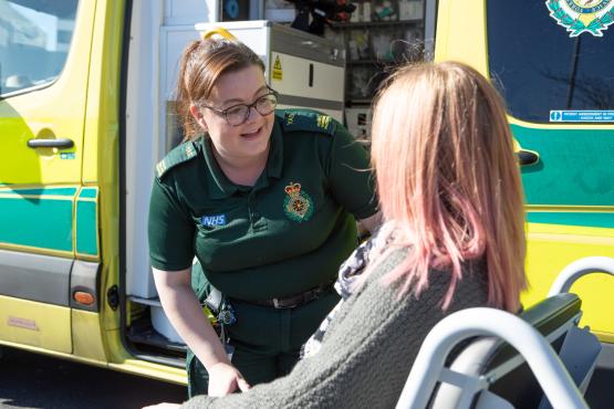 woman_in_a_wheel_chair_outside_an_ambulance_talking_to_paramedic