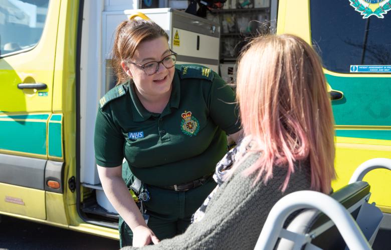 woman_in_a_wheel_chair_outside_an_ambulance_talking_to_paramedic