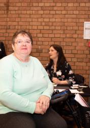 Woman sitting on a mobility scooter at an indoor event