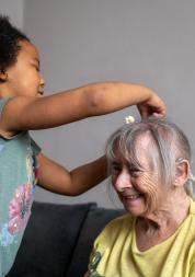 Elderly_woman_having_her_hair_played_with_by_a_little_girl