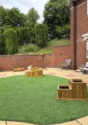 photograph showing outside space with artificial grass and home made wooden planters